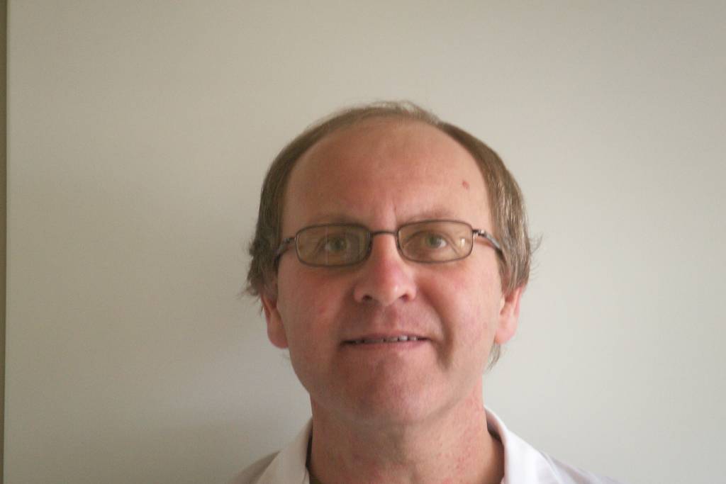 Portrait de Jacques Botte en blouse de laboratoire au travail.