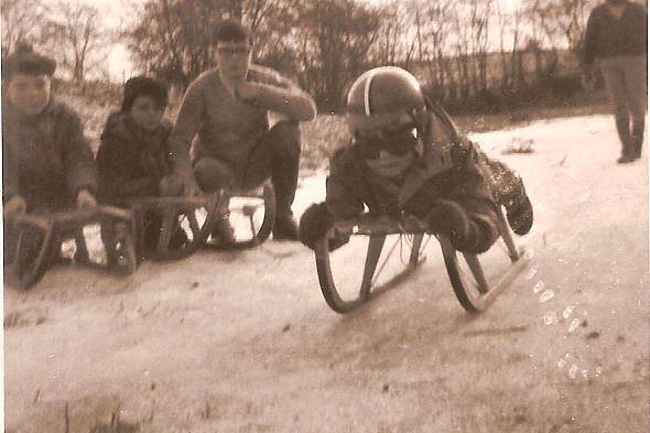 Jacques dans la neige avec son casque rouge et sa petite voiture rouge préférée, hiver 1968.