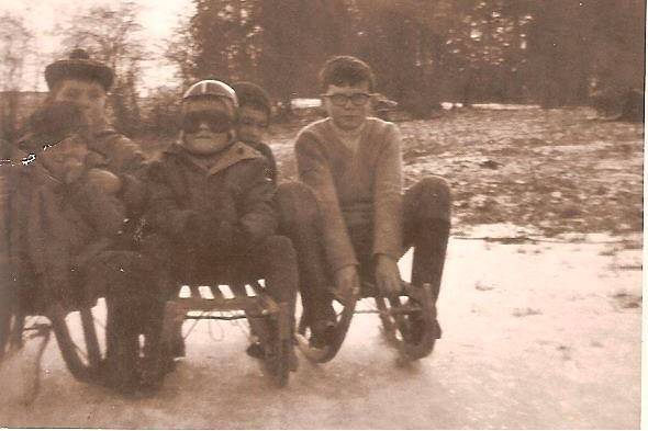 Un petit garçon au casque rouge sur une luge en bois dans la neige, à Soumoy, en 1968.