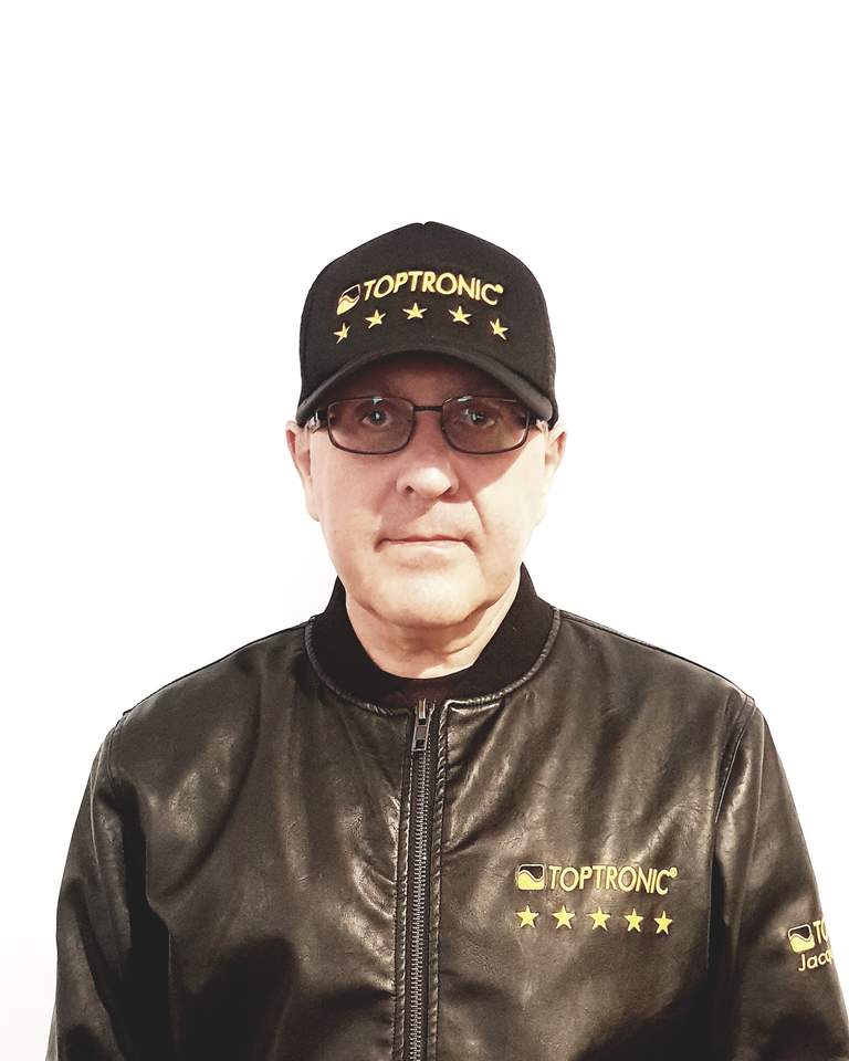 Portrait de Jacques Botte portant la casquette et la veste Toptronic® aux cinq étoiles, sur fond blanc.