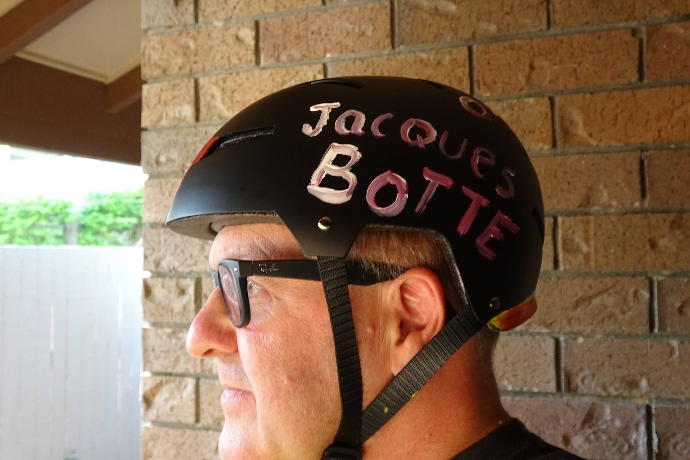 Jacques Botte portant le casque peint à la main à son nom.